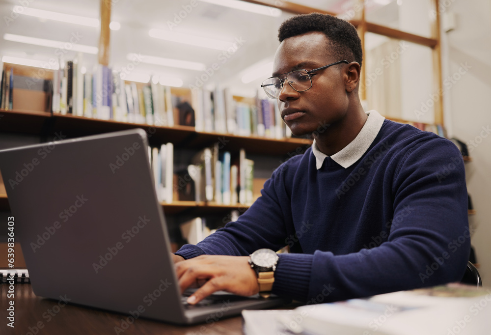 Student, library and black man typing on a laptop in university or college campus working on assignm