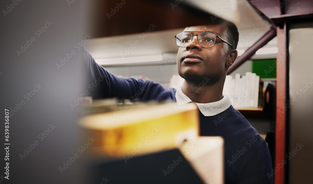 Knowledge, research and black man in a library search and learning on campus for studying and educat