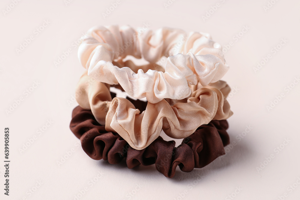 Set of stylish scrunchies on color background