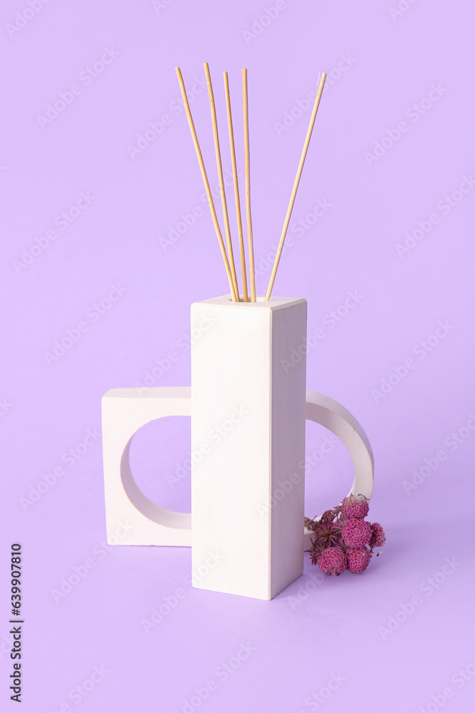 Floral reed diffuser and flowers on purple background