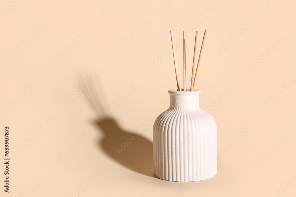 Bottle of reed diffuser on beige background