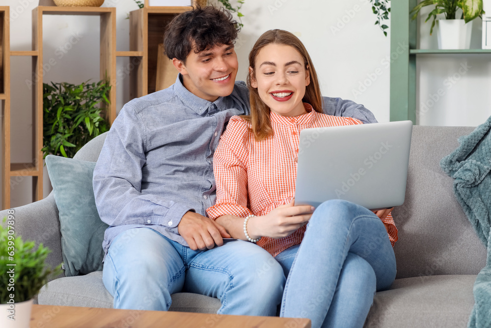 Young couple with laptop shopping online at home