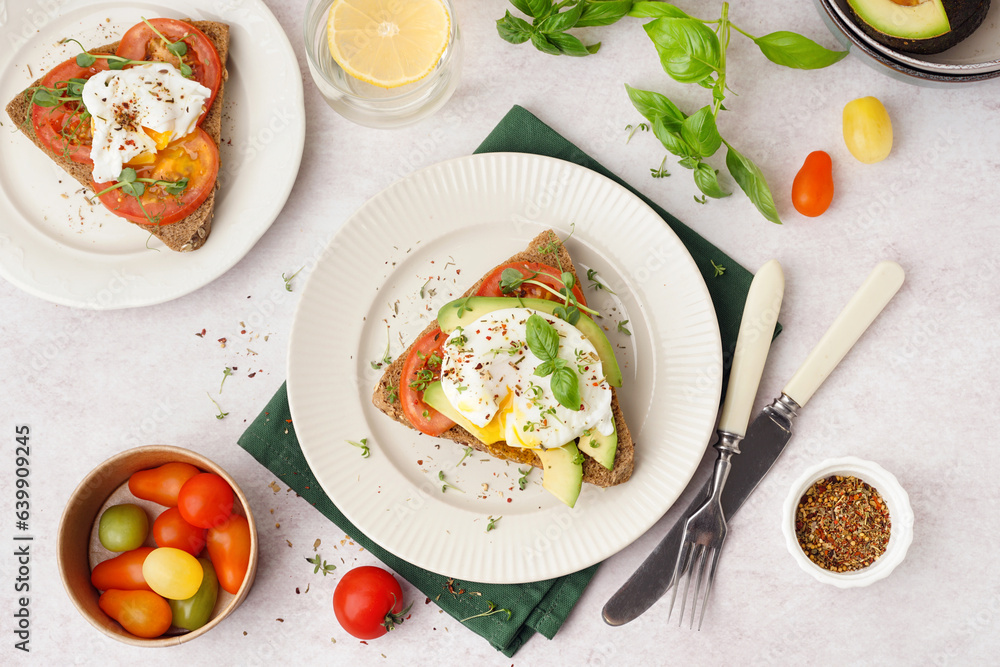 Plates of tasty sandwiches with egg on light background