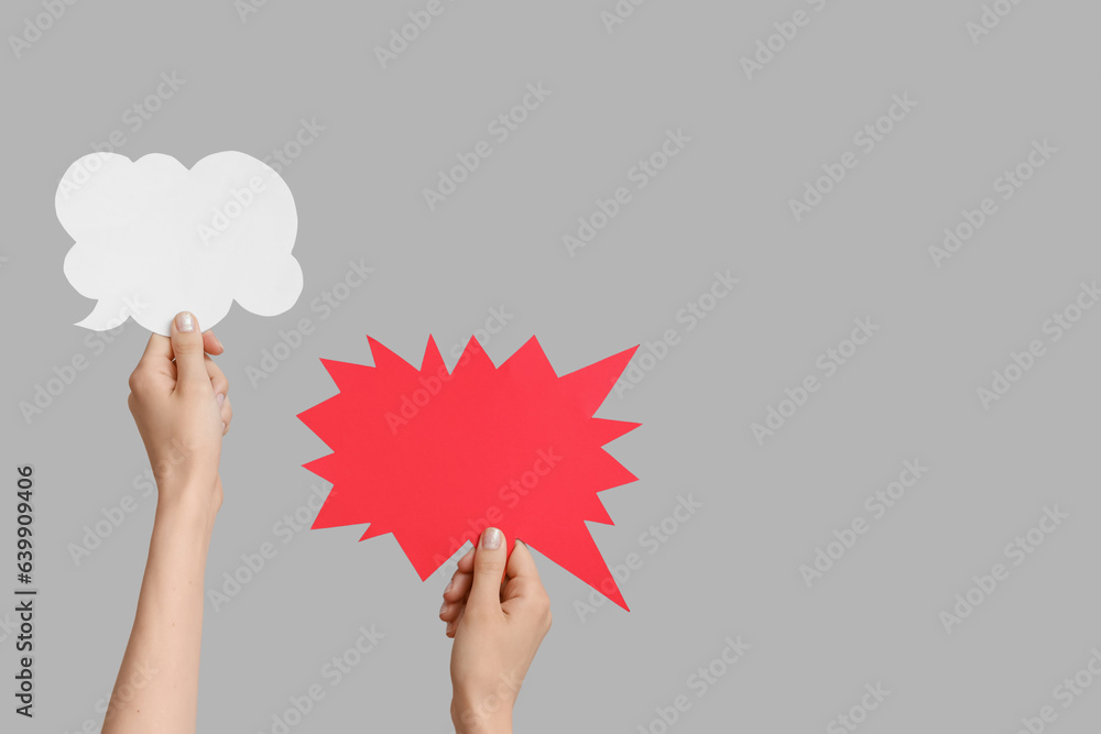 Female hands with speech bubbles on grey background