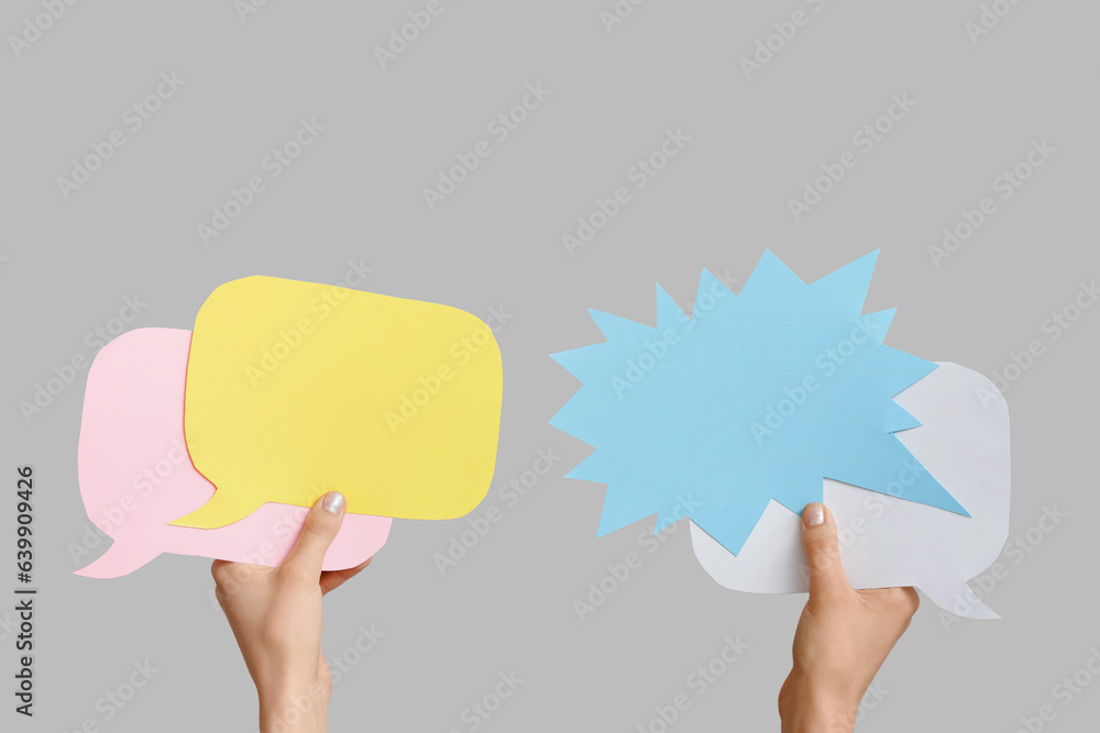 Female hands with speech bubbles on grey background