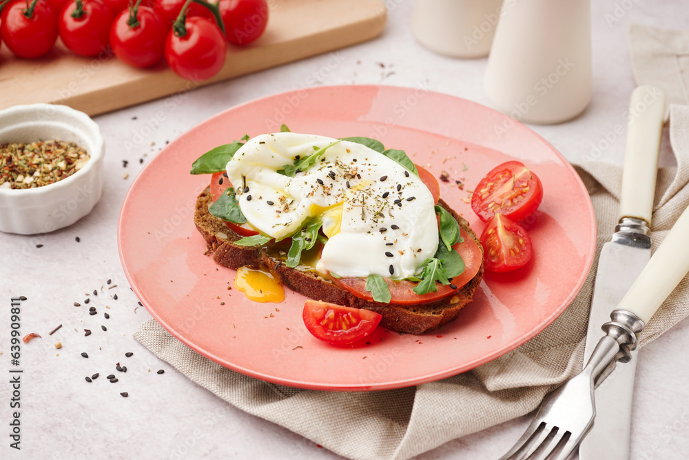 Plate of tasty sandwich with egg on light background