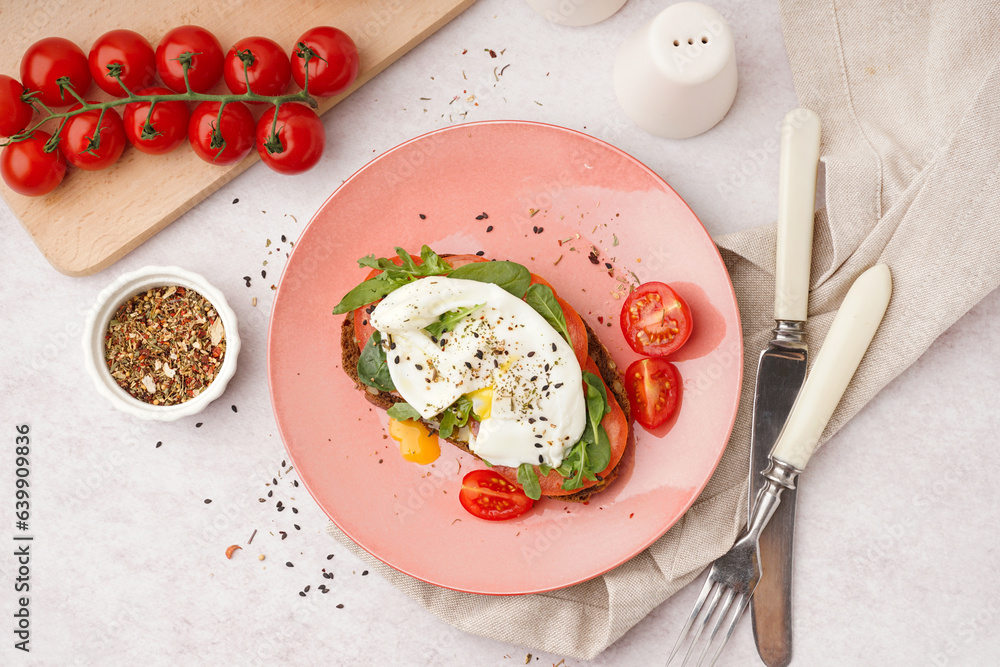 Plate of tasty sandwich with egg on light background