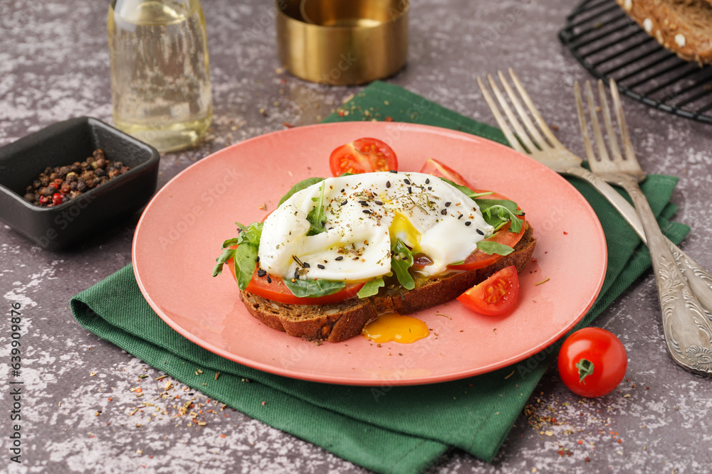 Plate of tasty sandwich with egg on grey background