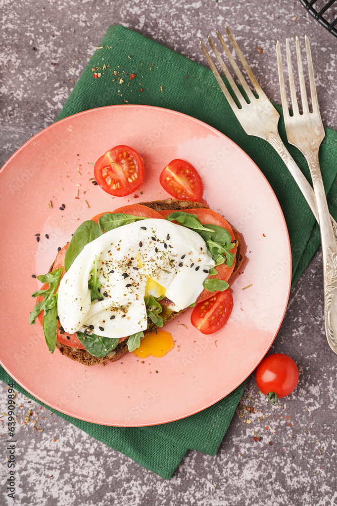 Plate of tasty sandwich with egg on grey background