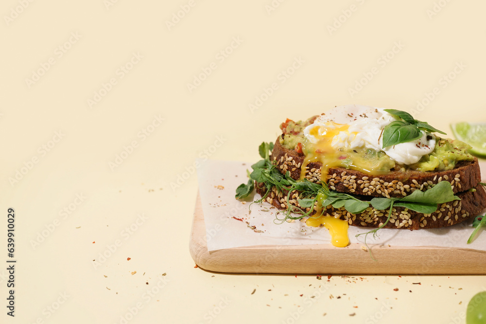 Wooden board of tasty sandwich with egg on yellow background