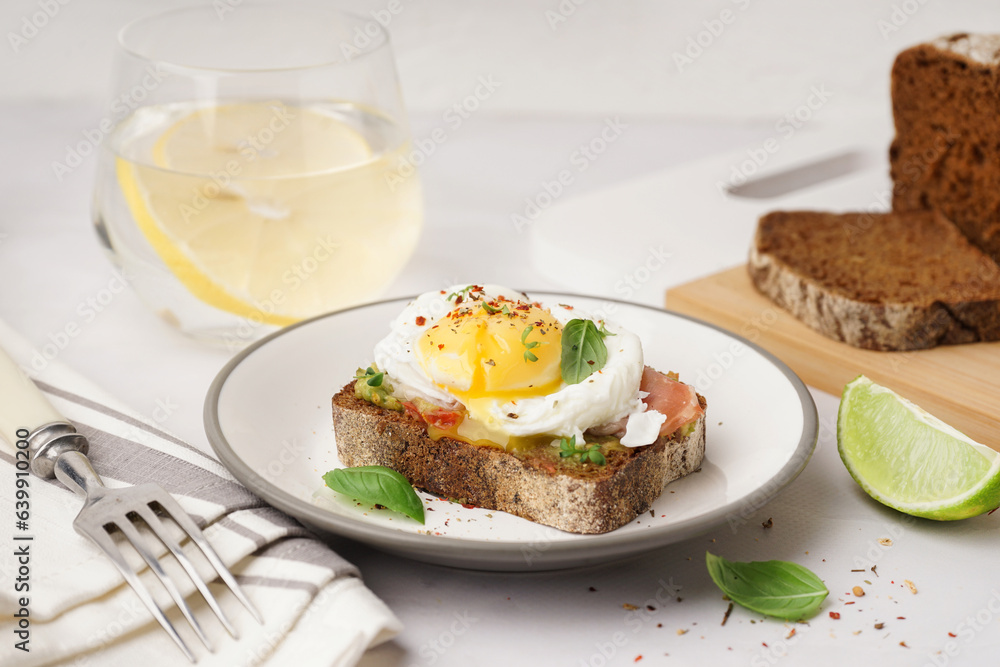 Plate of tasty sandwich with egg on grey background