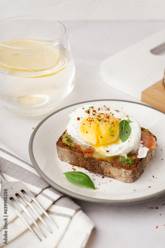 Plate of tasty sandwich with egg on grey background