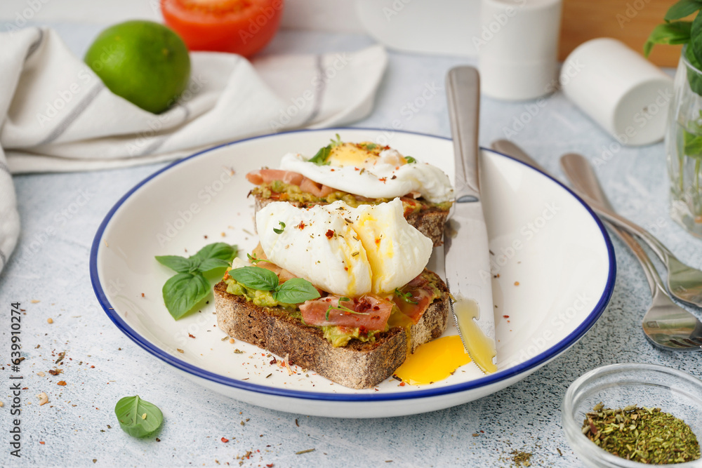 Plate of tasty sandwiches with egg on grey background