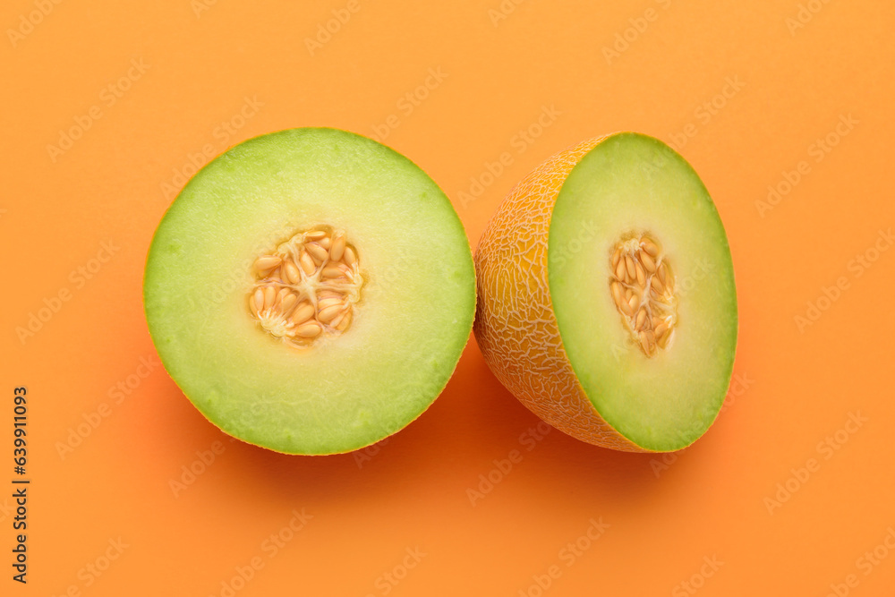 Halves of ripe melon on orange background