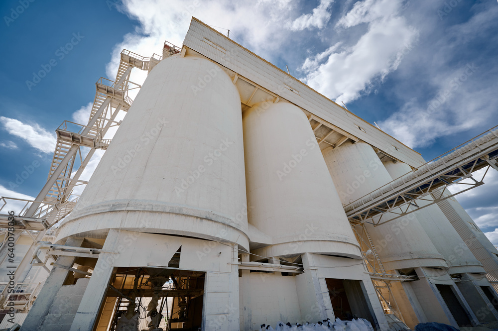 Huge concrete silos for lime storage against cloudy sky