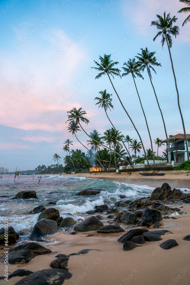 Sunrise with fishermen in Unawatuna, Sri Lanka, beach, palm trees and ocean