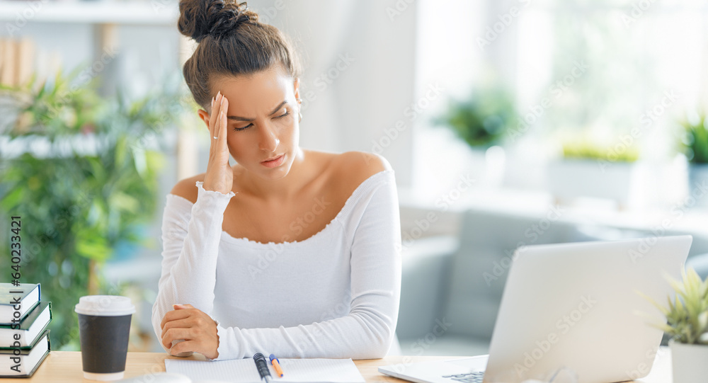 Young woman studying and having a head ache