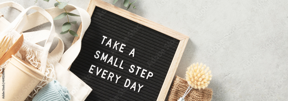 Take a small step every day letter board and zero waste no plastic accessories on grey stone backgro