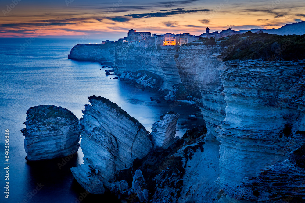 Bonifacio fortress on a cliff in the Corsican shoreline at sunset, Corse, France