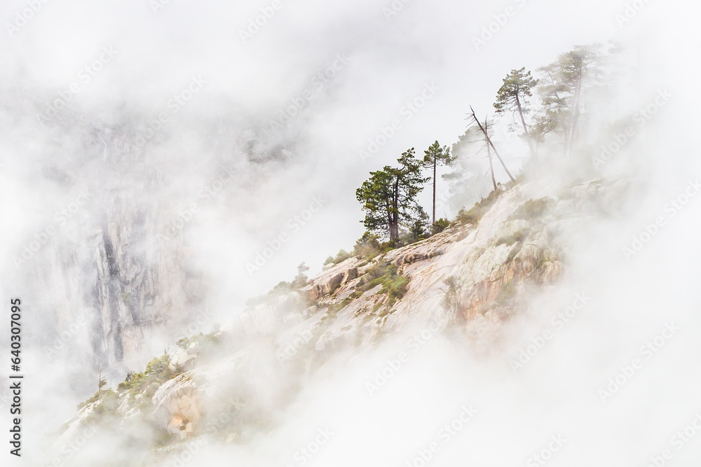 Rocky mountain slope in clouds in Corse, France