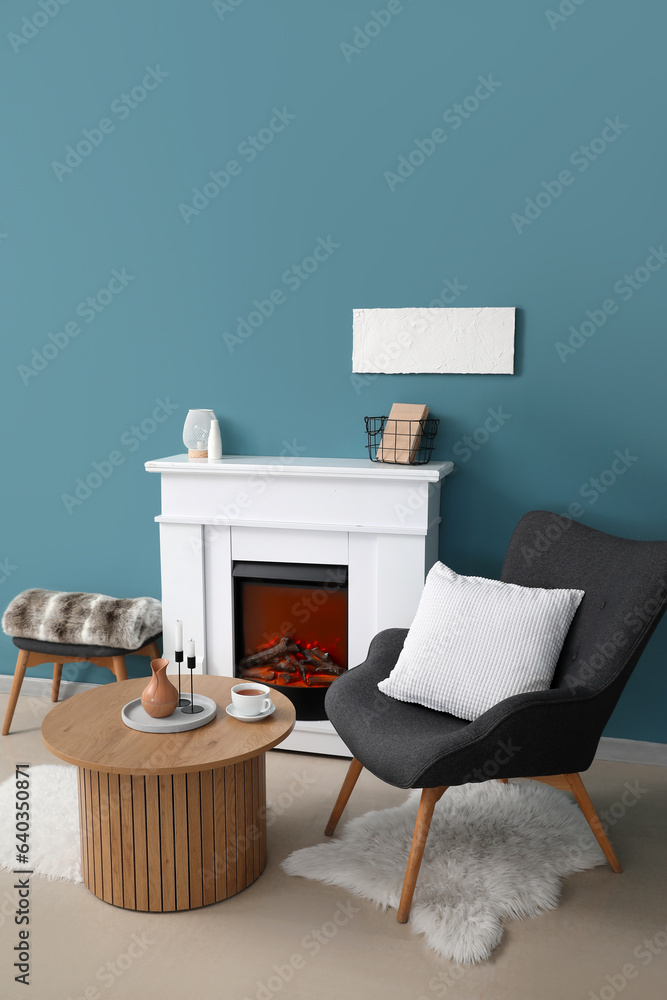 Coffee table with cup of tea, jug and candles in living room