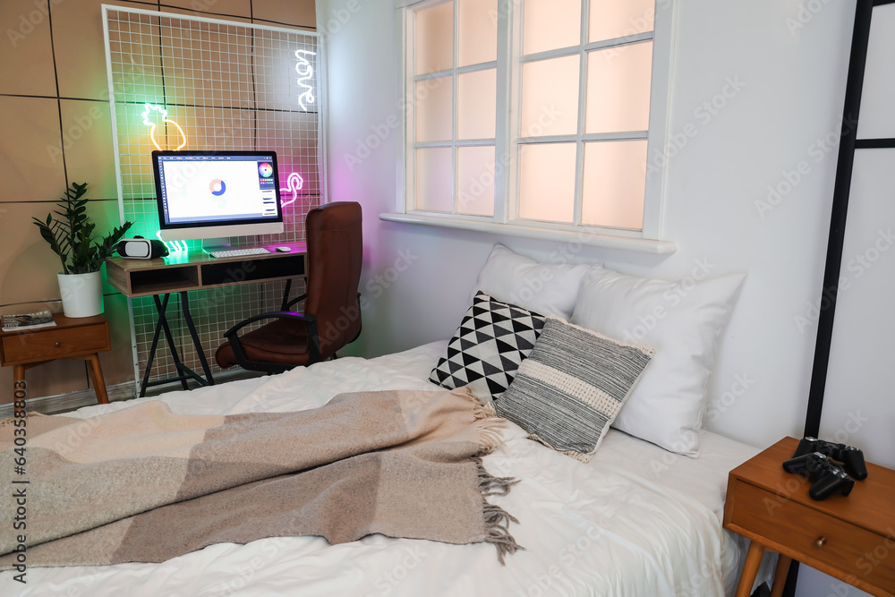 Interior of childrens bedroom with cozy bed and modern computer on table