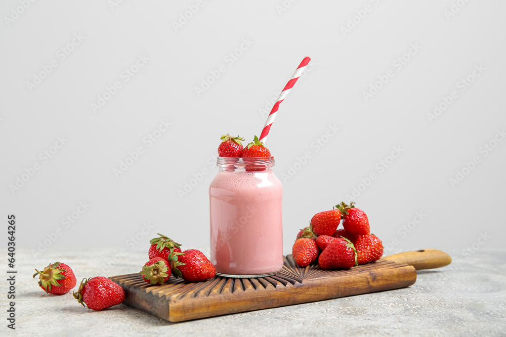 Mason jar of tasty strawberry smoothie on table