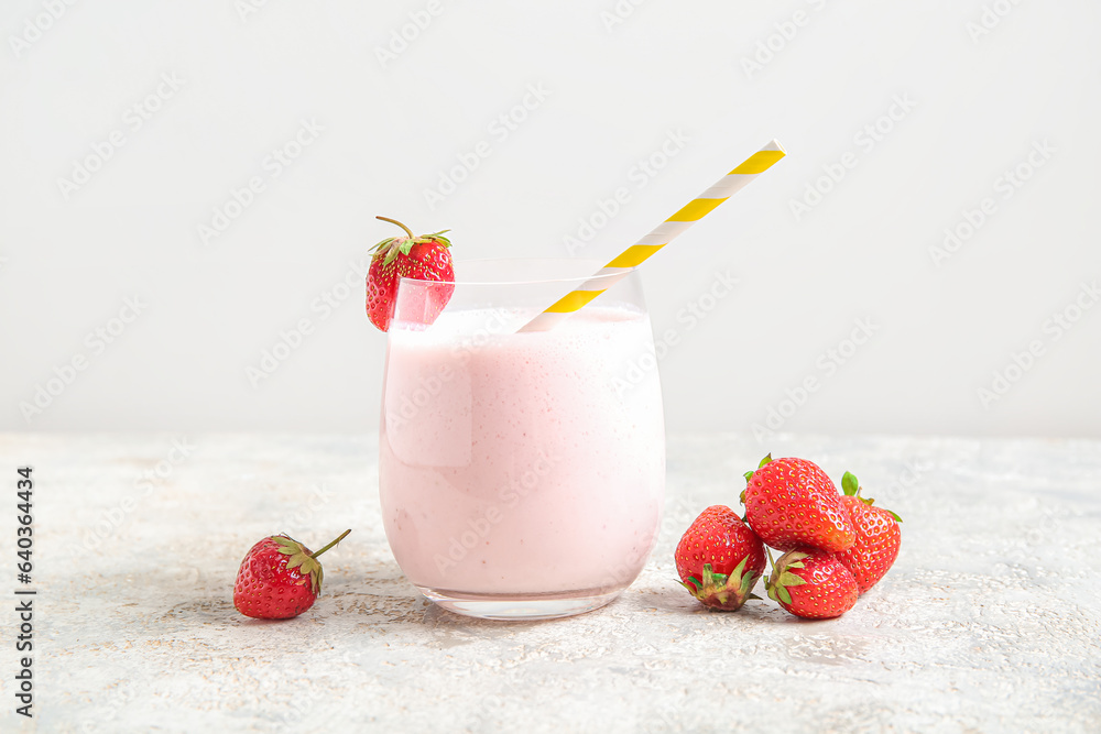 Glass of tasty strawberry smoothie on table