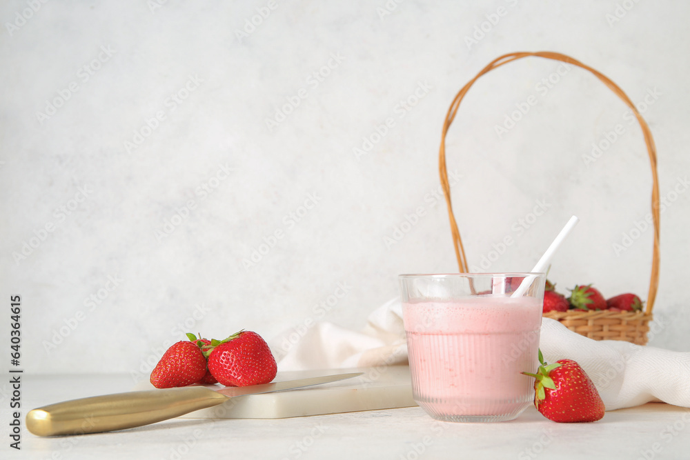 Glass of tasty strawberry smoothie on light background