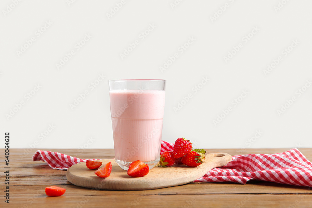 Glass of tasty strawberry smoothie on table