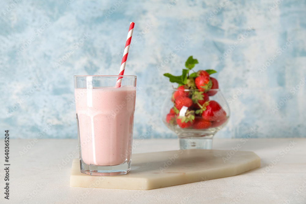 Glass of tasty strawberry smoothie on table