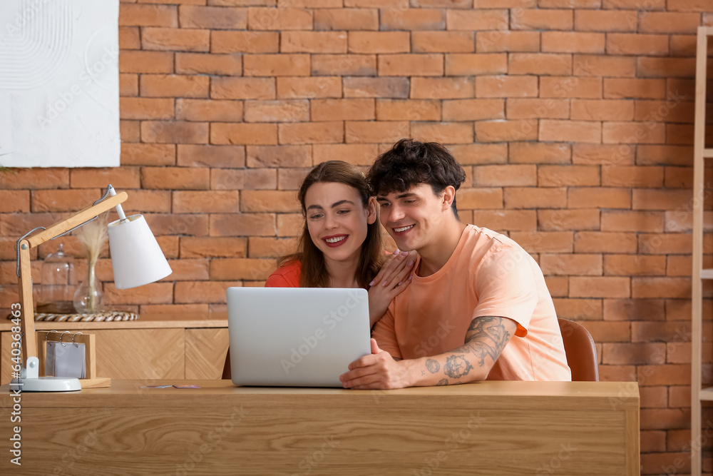 Young couple with laptop shopping online at home