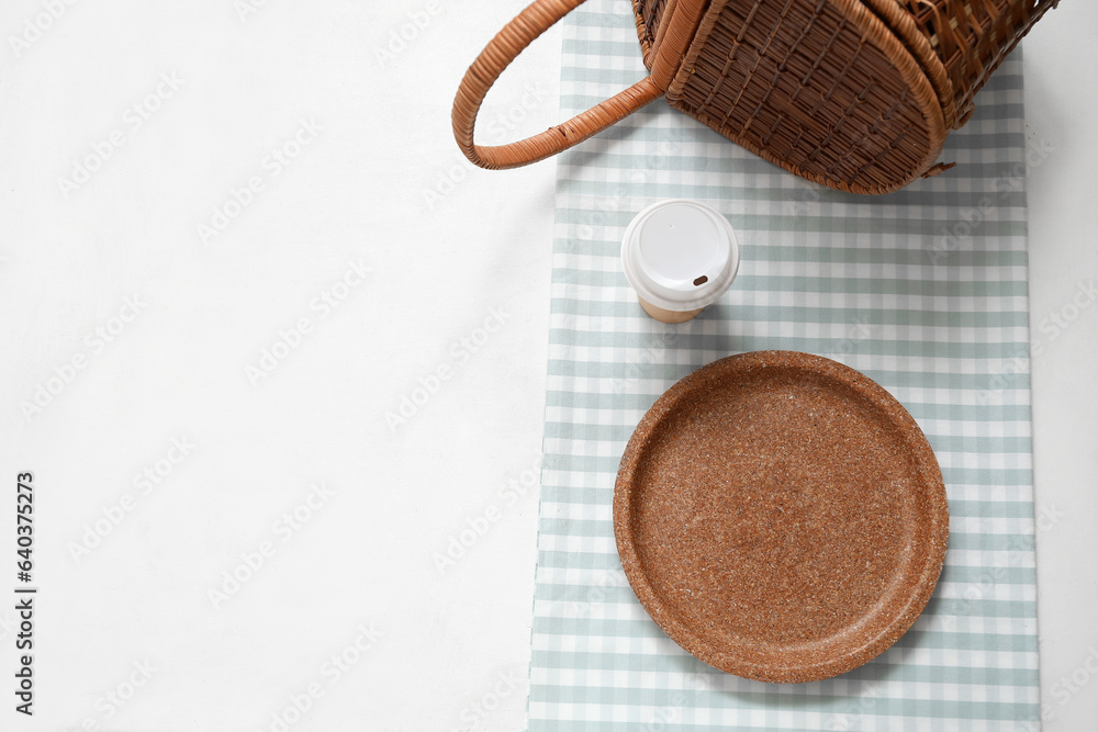 Disposable plate, cup and napkin on light background