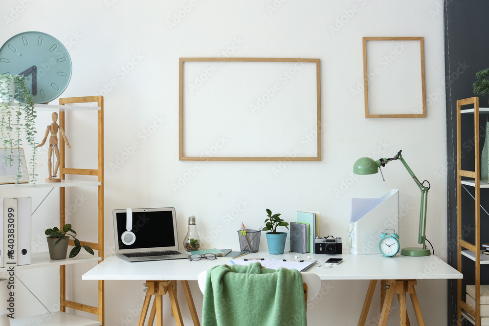 Interior of light office with workplace and frames