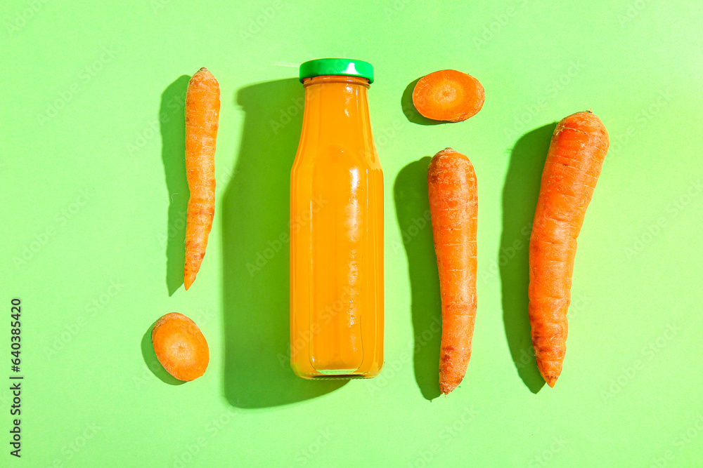 Bottle of fresh carrot juice on green background