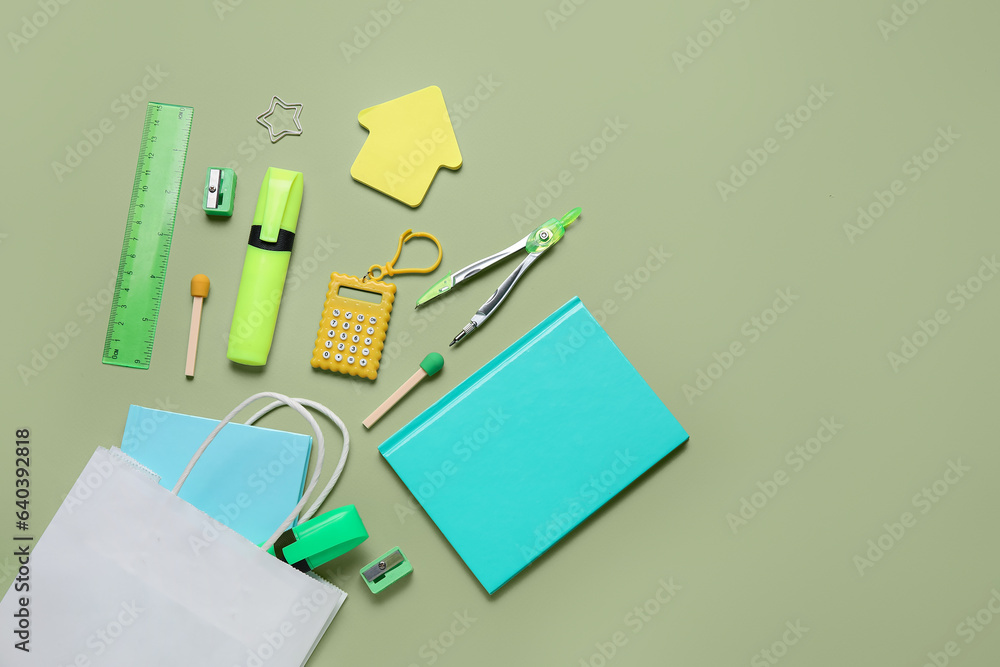 Composition with paper bag and different stationery on green background