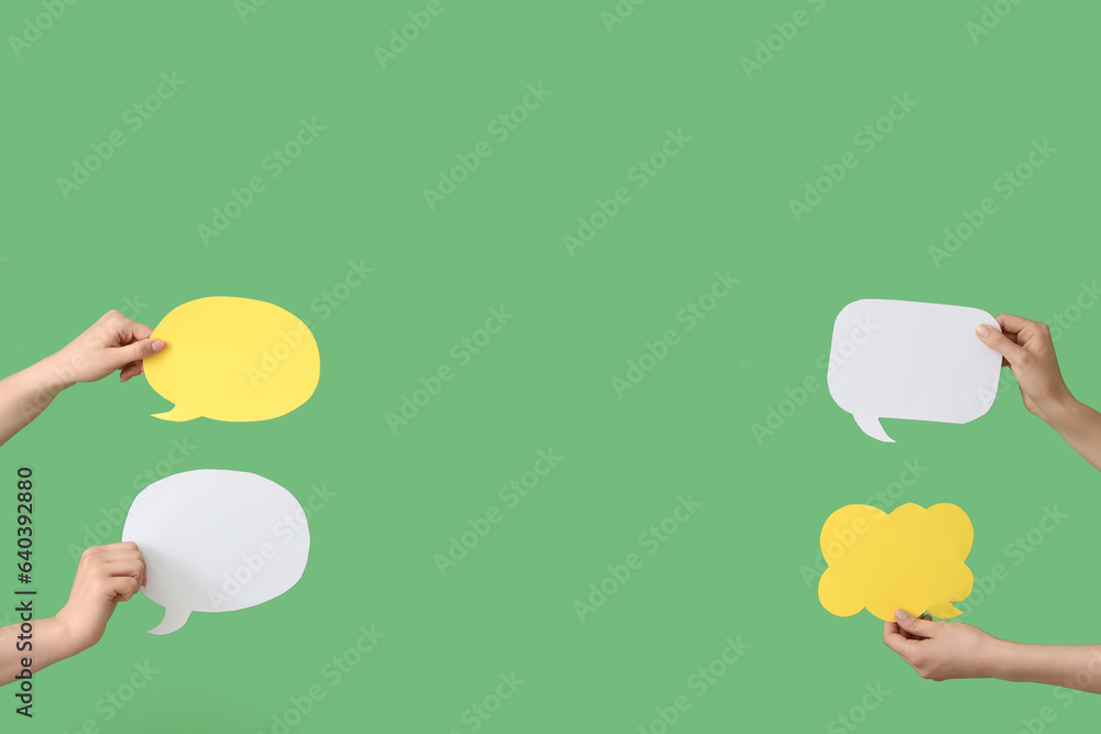 Female hands with speech bubbles on green background