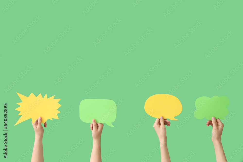 Female hands with speech bubbles on green background