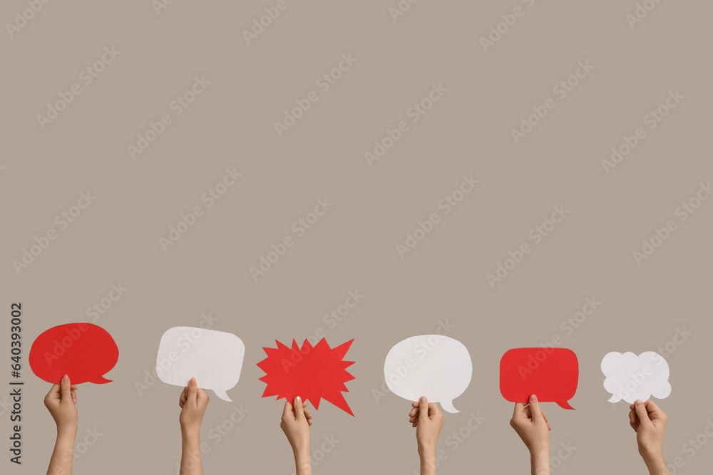 Different hands with speech bubbles on grey background