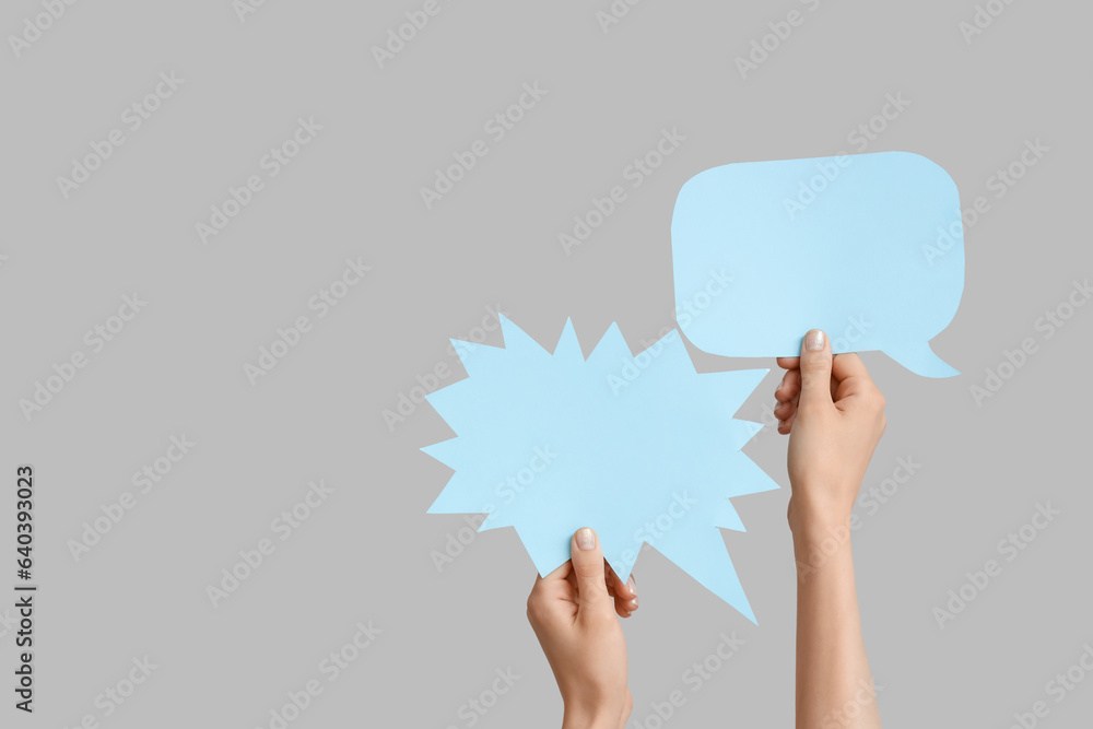 Female hands with speech bubbles on grey background