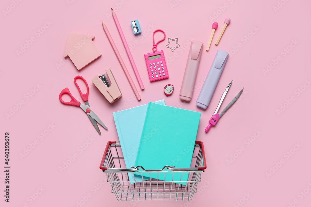 Shopping basket with different school stationery on pink background