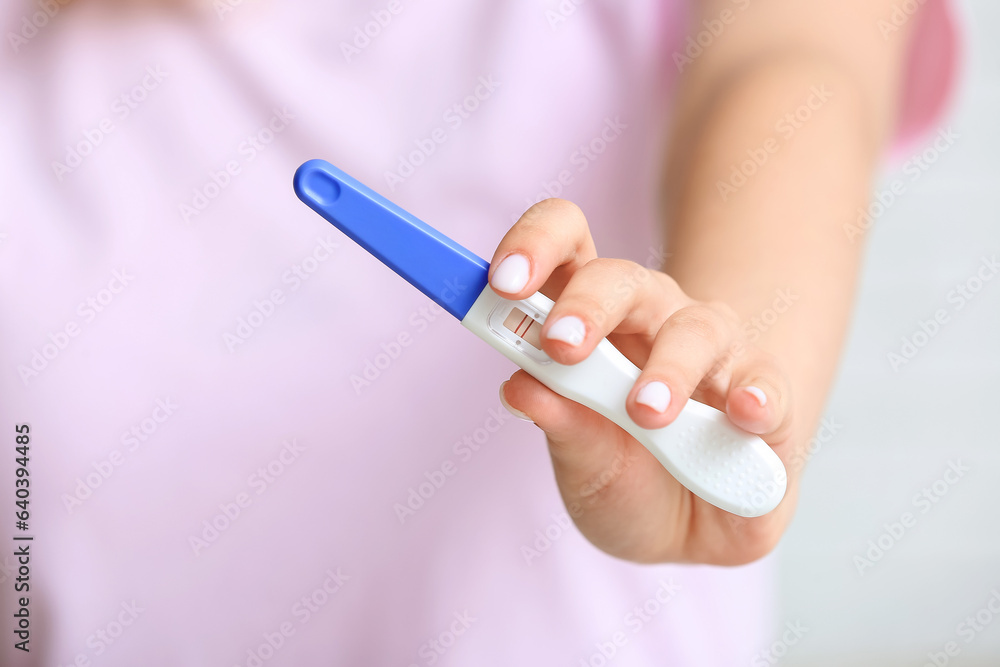 Female hand with positive pregnancy test, closeup