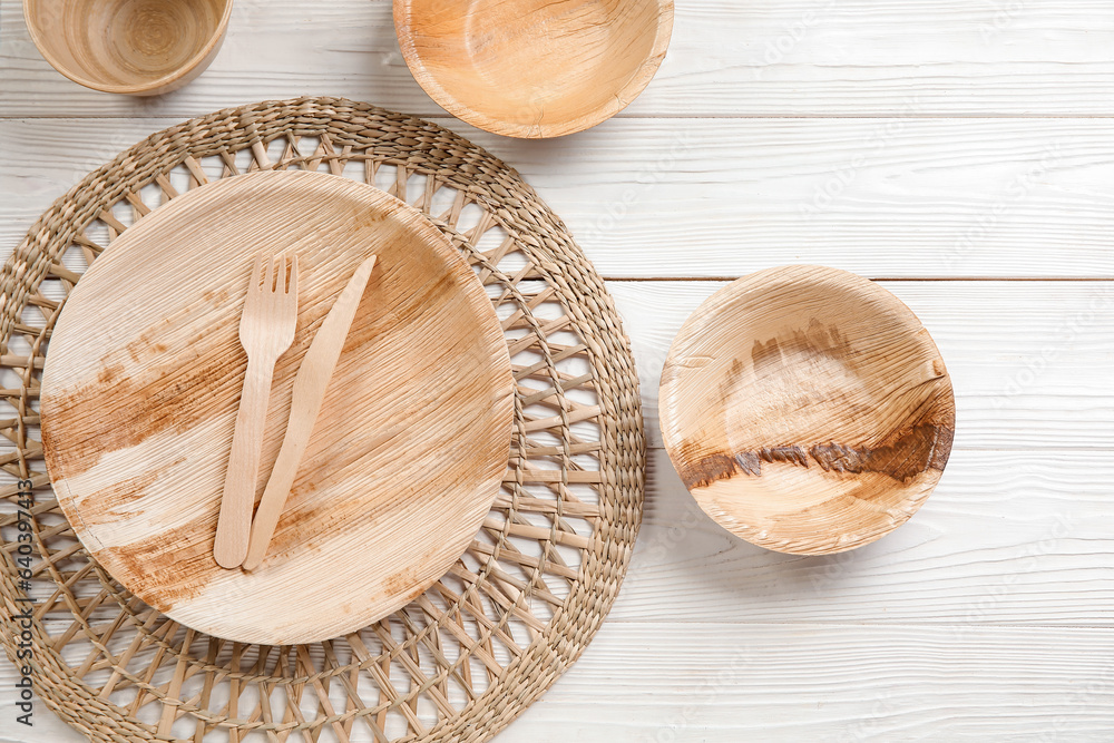 Different tableware on light wooden background