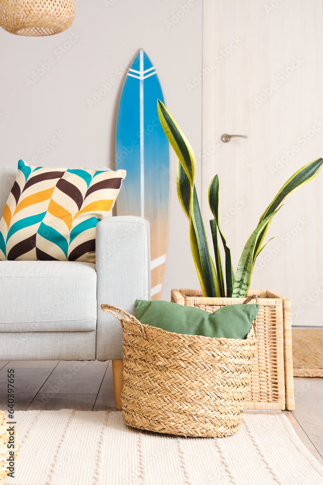 Wicker basket with surfboard in stylish living room