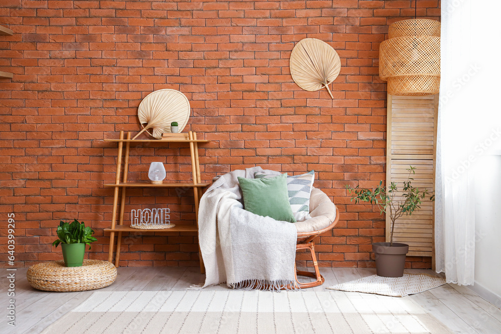 Stylish armchair with cushions and blanket in interior of living room