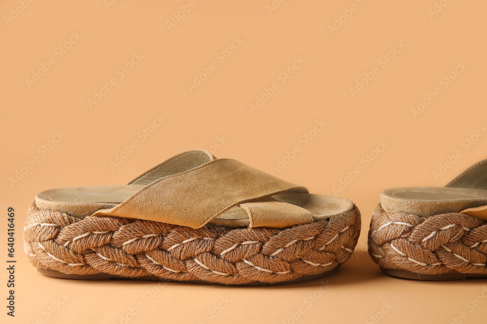 Stylish beige sandals on yellow background