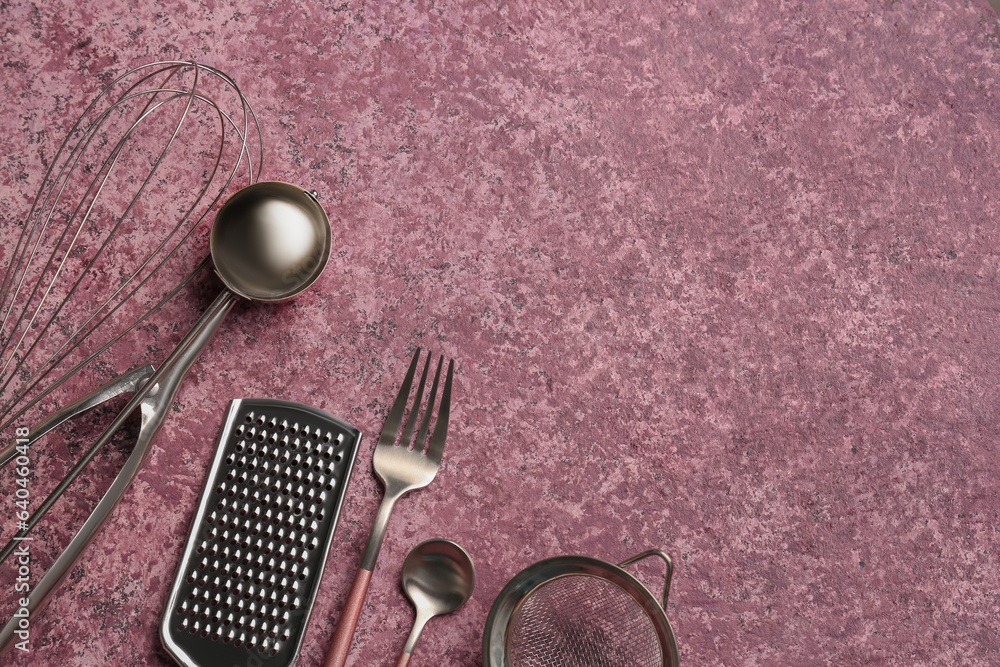 Different kitchen utensils on purple background