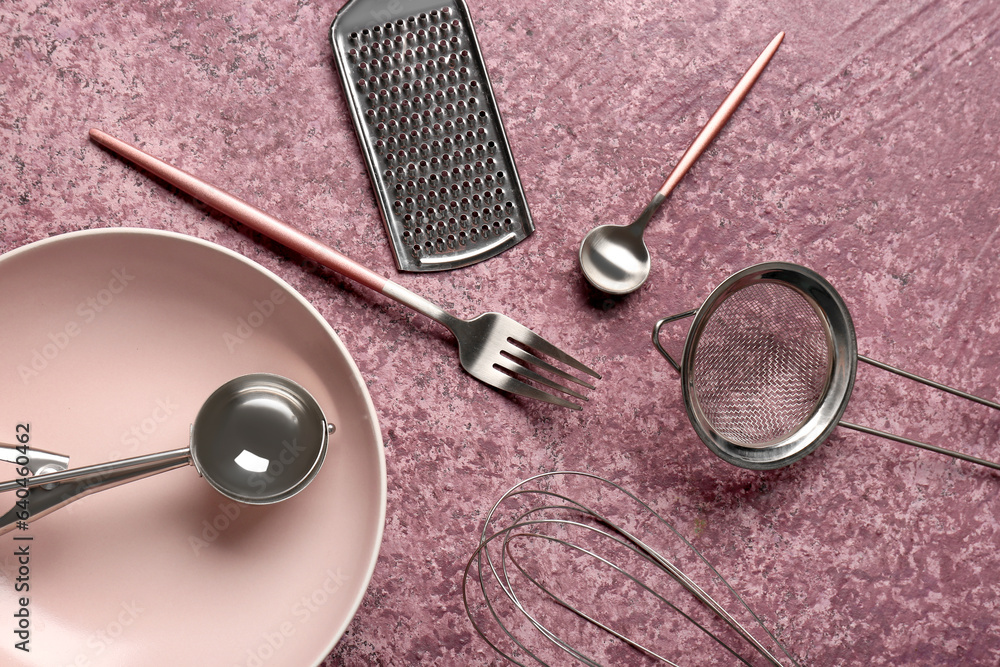 Different kitchen utensils on purple background