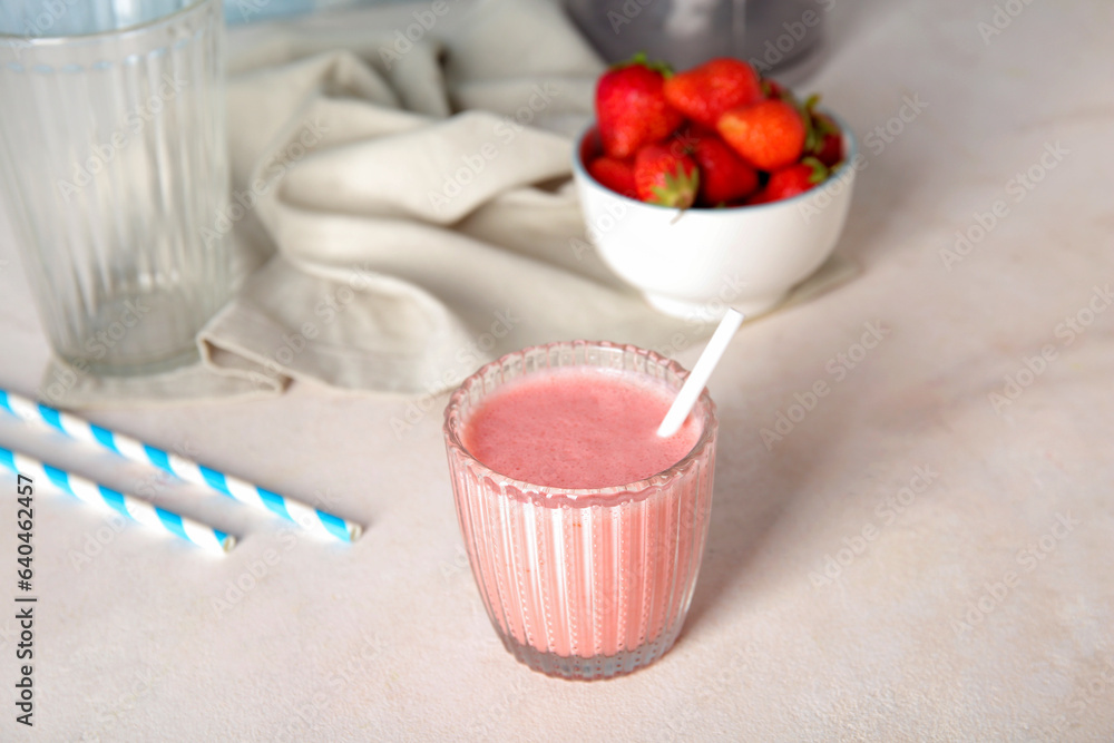 Glass of tasty strawberry smoothie on light background