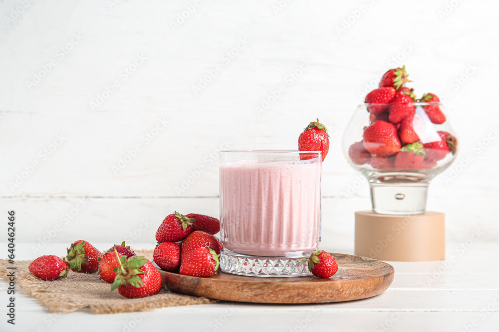 Glass of tasty strawberry smoothie on light background